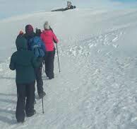 6 dys leomosho route. The group of hikers approaching the summit of kilimanjaro and passing over the snow